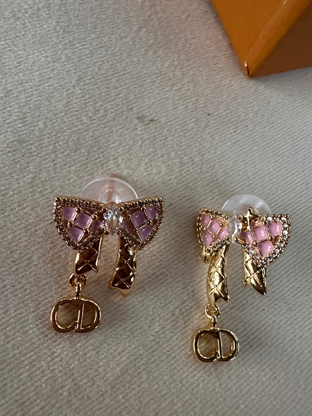 CD Gold Bow Drop Earrings with Pink Enamel Accents